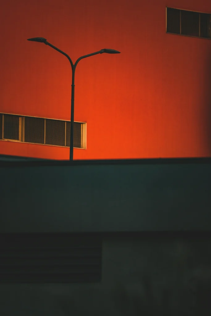 Image d'une rue montrant un bâtiment et un lampadaire, le mur du bâtiment est orange